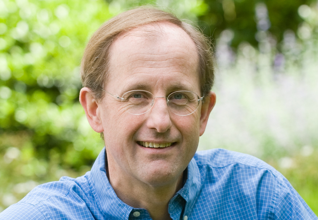 Auf dem Porträtfoto sieht man Jules Kortenhorst (CEO des RMI, Rocky Mountain Institute) im blauen Hemd vor Bäumen sitzen. Kortenhorst schreibt über Erneuerbare Energien.