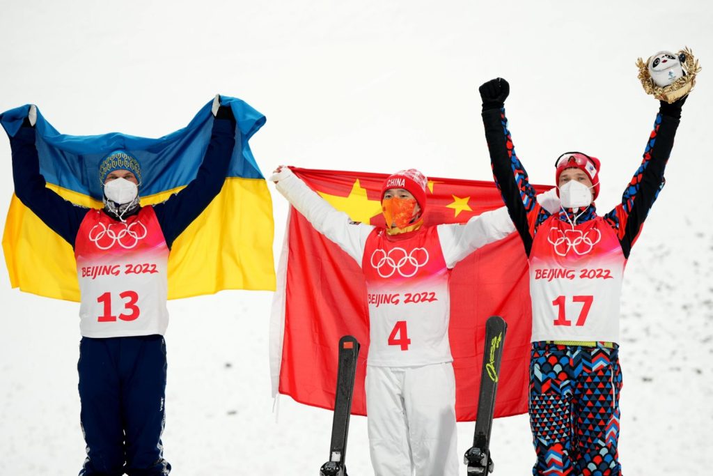Aerials-Olympiasieger Qi Guangpu und die beiden anderen Medaillengewinner bei der Blumenzeremonie im Genting Snow Park