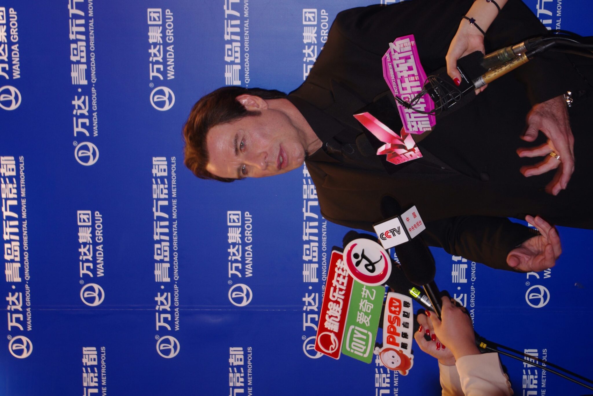 John Travolta muss Schaustehen: Auf Chinesisch hat ihn ein Reporter gefragt, was er von der Zusammenarbeit Chinas mit Hollywood halte. Nachdem übersetzt ist, spreizt er hilflos seine Finger und sagt: "Ich bin begeistert." 