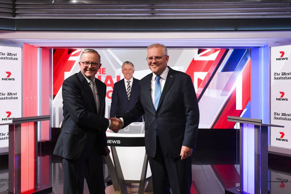 Die beiden Kandidaten Albanese und Morrison schütteln einander die Hände und gucken in die Kamera.