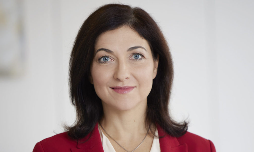 Man sieht Katharina Reiche in die Kamera lächelnd, sie kennt sich aus mit Netzen, Vernetzen und Führen.