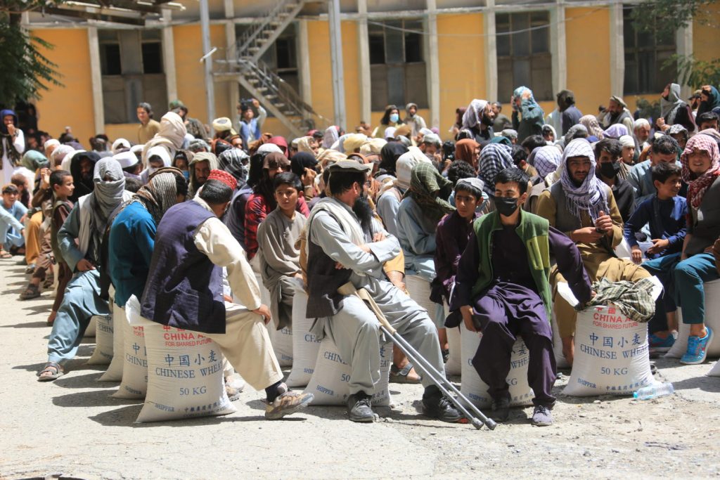 Männer in Kabul, Afghanistan, sitzen auf Weizensäcken aus China