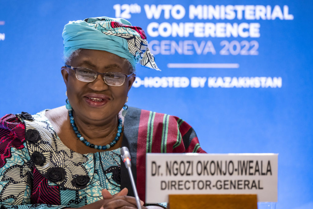 Man sieht Ngozi Okonjo-Iweala, Generaldirektorin der Welthandelsorganisation (WTO), vor einem blauen Hintergrund bei der WTO Ministerial Conference 2022 an einem Pult.