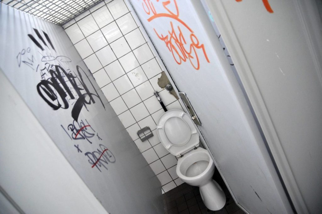 Man sieht eine Toilette mit Grafitti