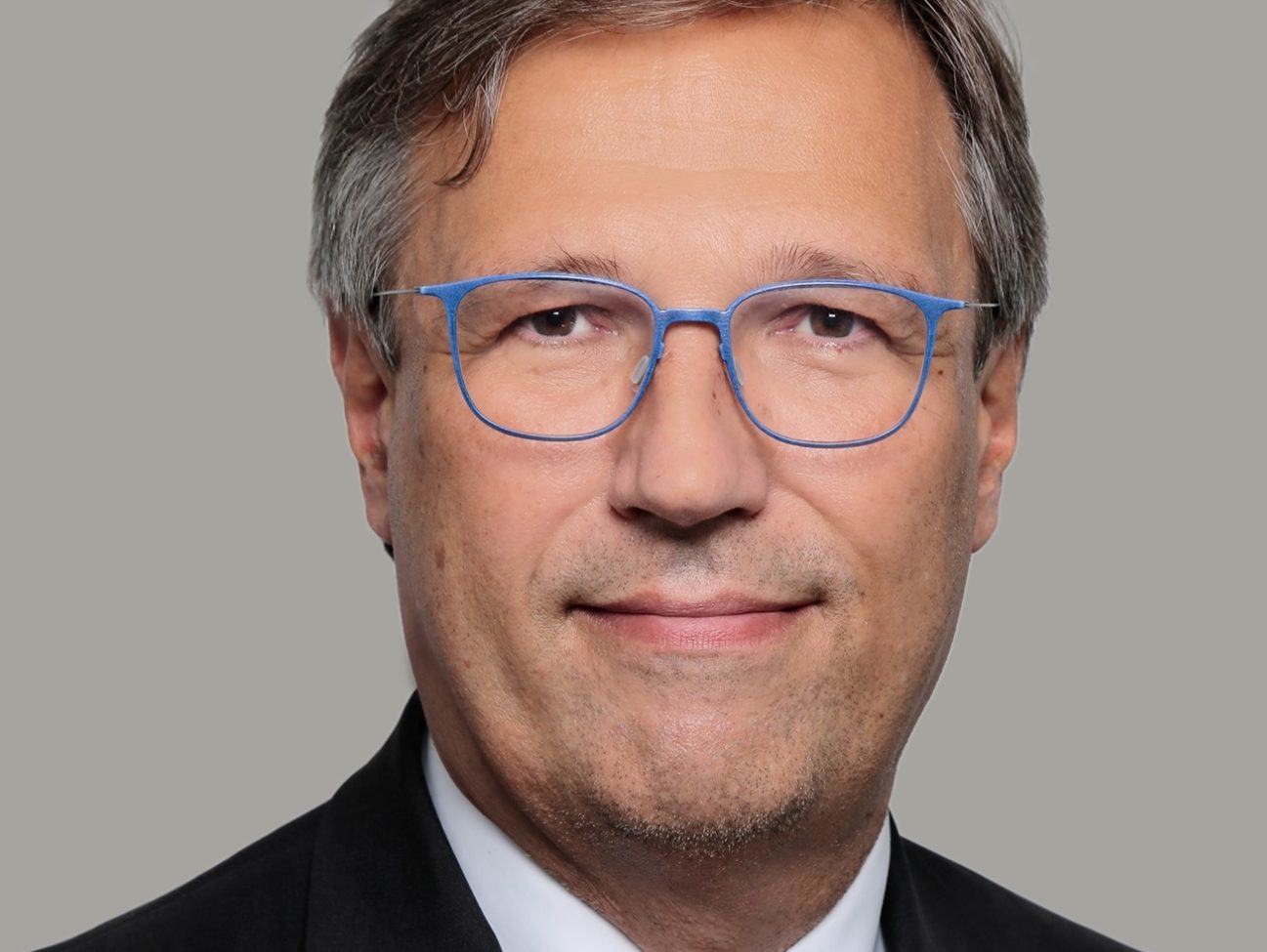 Porträtfoto von Stefan Mair (SWP) mit blauer Brille und Anzug. 