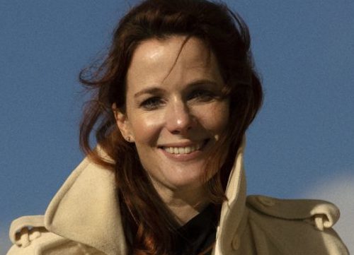 Porträtfoto von Florence Gaub mit beiger Jacke vor blauem Himmel. 