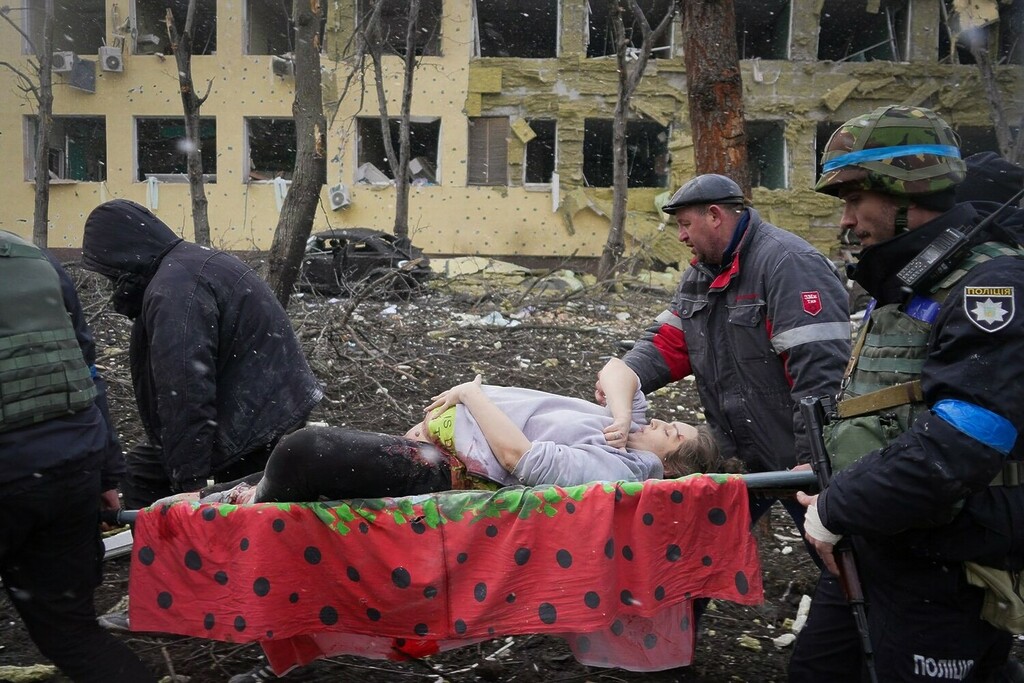 Helfer tragen eine schwangere Frau in Mariupol.