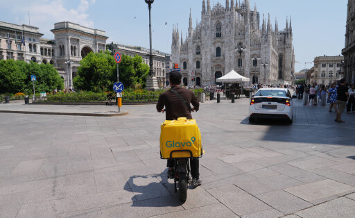 Milan, Glovo Raider with the heat in the traffic in Piazza Duomo Copyright: xDuilioxPiaggesix xipa-agency.netx xDuilioxPiaggesix IPA_Agency_IPA59924075
