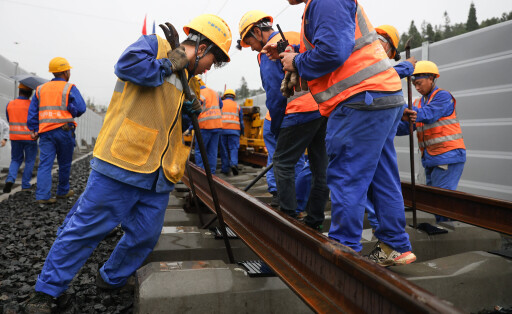 Arbeiter verlegen Eisenbahnschienen in Panzhou, Guizhou