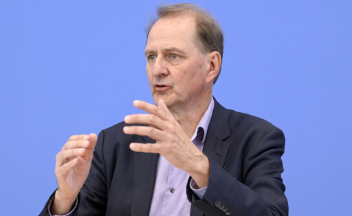 Dirk Messner trägt einen Anzug und ein fliederfarbenes Hemd. Er ist auf der Bundespressekonferenz, der Hintergrund ist im typischen Blau.