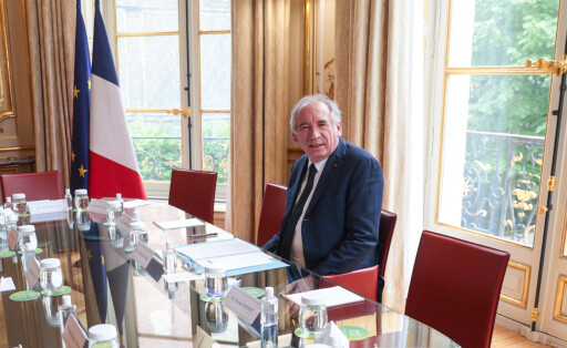 Francois Bayrou sitzt alleine an einem Konferenztisch