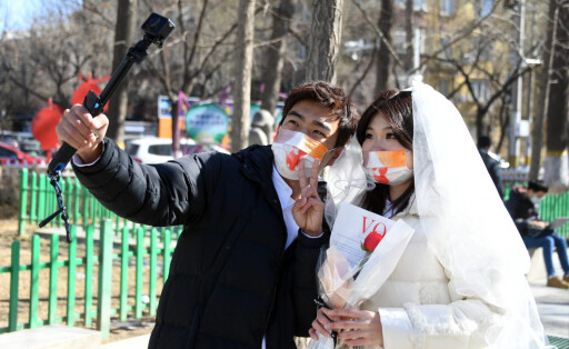 220222 -- BEIJING, Feb. 22, 2022 -- A couple poses for a photo outside a marriage registry of Haidian District in Beijing, capital of China, Feb. 22, 2022. Feb. 22 of 2022, a date with numbers of 2s that roughly resonant the pronunciation of love in spoken Chinese, is prefered by couples to registrate marriage for good wishes. CHINA-20220222-COUPLE-LOVE CN RenxChao PUBLICATIONxNOTxINxCHN