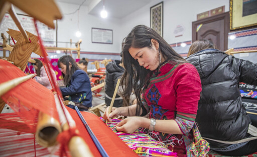 220322 -- CHONGQING, March 22, 2022 -- Women make products of Xilankapu, which is a kind of Tujia brocade, at a studio in Xiaonanhai Town of Qianjiang District in southwest China s Chongqing, March 22, 2022. Xilankapu, also known as knitting Floral Bedclothes, was listed as national intangible cultural heritage in 2006. CHINA-CHONGQING-TUJIA BROCADE CN HuangxWei PUBLICATIONxNOTxINxCHN