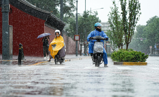 230730 -- BEIJING, July 30, 2023 -- People ride scooters on a street amid the rain in Beijing, capital of China, July 30, 2023. Impacted by Typhoon Doksuri, the fifth typhoon of this year, heavy rainfall has hit north China regions, including Beijing, Hebei and Shandong. CHINA-BEIJING-RAINSTORM CN ChenxZhonghao PUBLICATIONxNOTxINxCHN