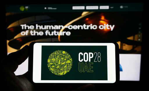 Person holding mobile phone with logo of UN climate change conference COP28 Dubai on screen. Stuttgart, Germany - 03-25-2023: Person holding mobile phone with logo of UN climate change conference COP28 Dubai on screen in front of web page. Focus on phone display. Copyright: xZoonar.com/TimonxSchneiderx 20081766
