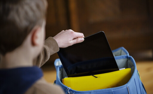 Kind steckt Tablet in den Schulranzen.