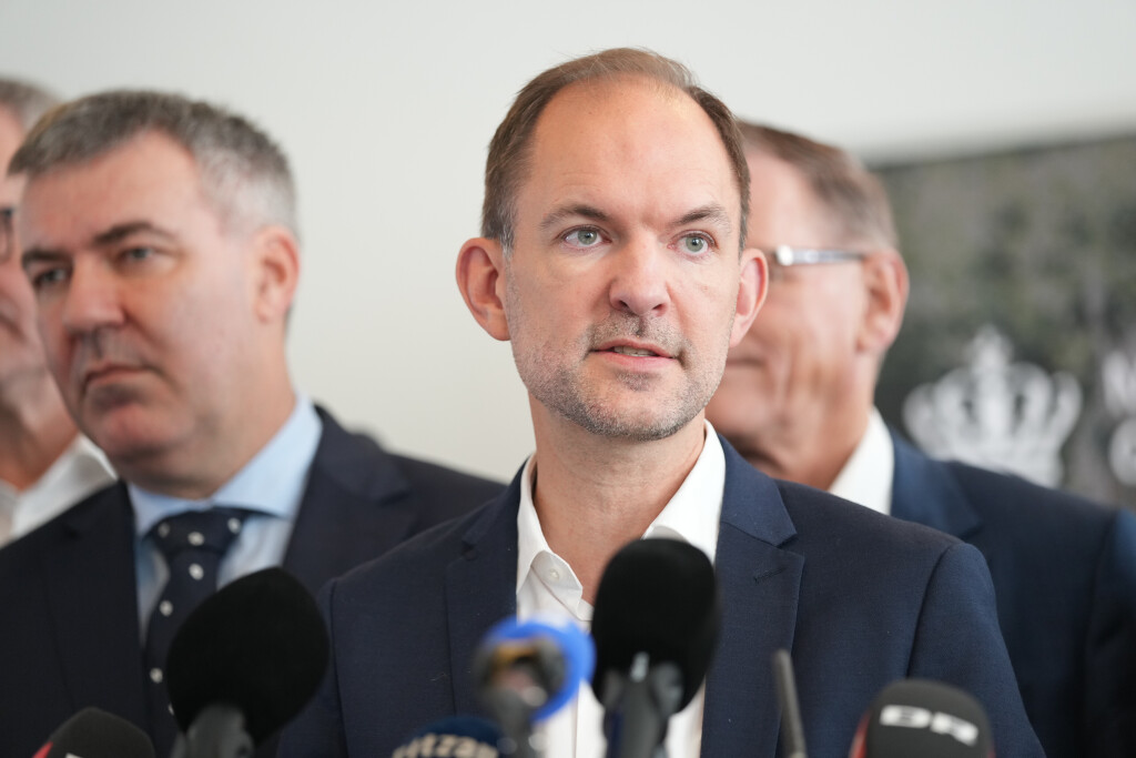 Jeppe Bruus spricht auf einer Pressekonferenz in Mikrophone.