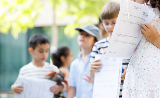 Kinder halten Schulzeugnis in der Hand.
