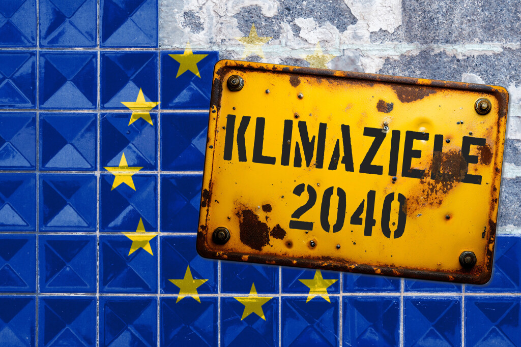 Ein rostiges Schild mit der Aufschrift "Klimaziele 2040" auf einer gekachelten Europaflagge.