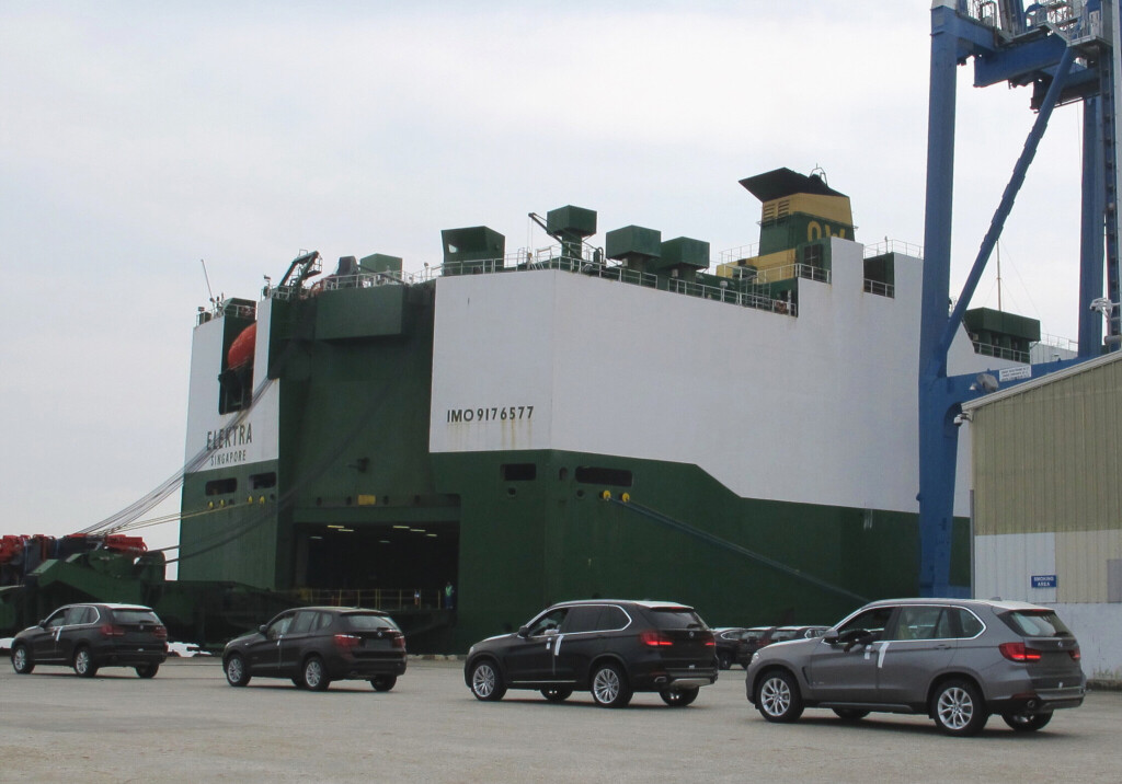 Autos der Marke BMWs warten bis sie in ein Autotransportschiff einfahren können.