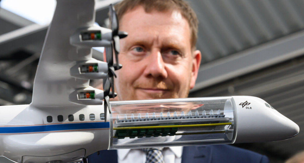 Michael Kretschmer (CDU), Ministerpräsident von Sachsen, steht beim 19. Tag der Deutschen Luft- und Raumfahrtregionen am Flughafen Dresden International an einem Modell „H2 Electra“ des Deutschen Zentrums für Luft- und Raumfahrt (DLR), welches die hohe technische Komplexität neuartiger Antriebssysteme visualisiert.