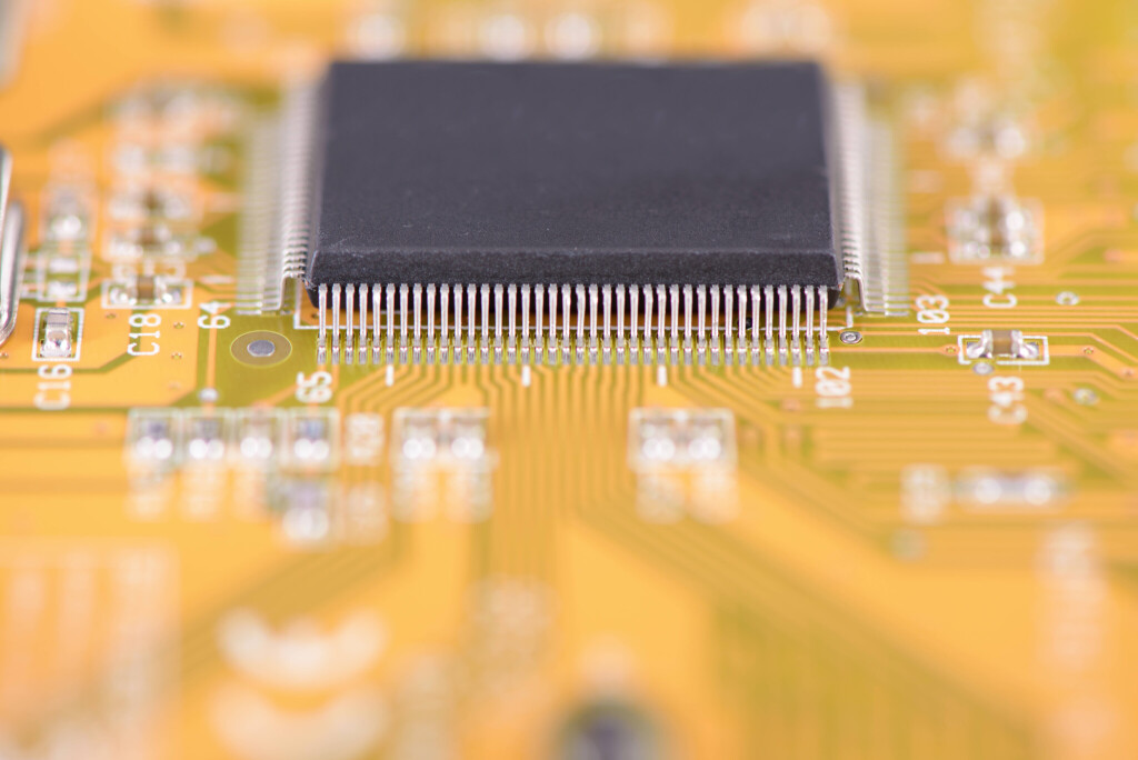 Auf einem Elektronik-Board sind Transistoren und Mikrochips in einem Netzwerk miteinander verbunden, als Symbolbild für High-Tech-Elektronik in der Industrie - digital bearbeitet.