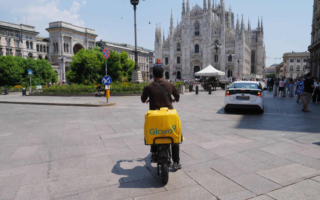 Milan, Glovo Raider with the heat in the traffic in Piazza Duomo Copyright: xDuilioxPiaggesix xipa-agency.netx xDuilioxPiaggesix IPA_Agency_IPA59924075