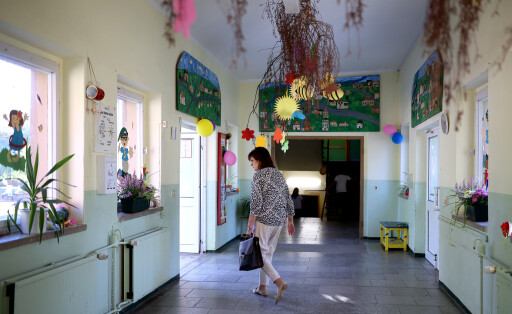 Eine Schulleiterin läuft in einer Grundschule den Gang entlang.