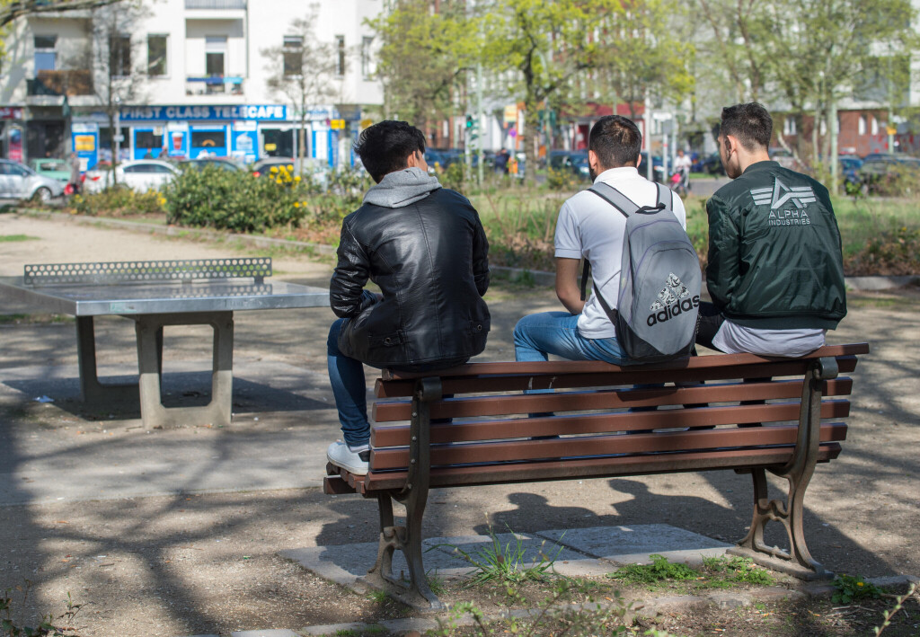 Junge Männer auf einer Parkbank.