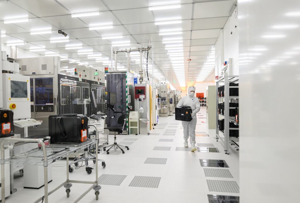 Ein Mitarbeiter geht im Fraunhofer-Institut für Photonische Mikrosysteme IPMS durch einen Reinraum zur Herstellung von 300-Millimeter-Wafern.