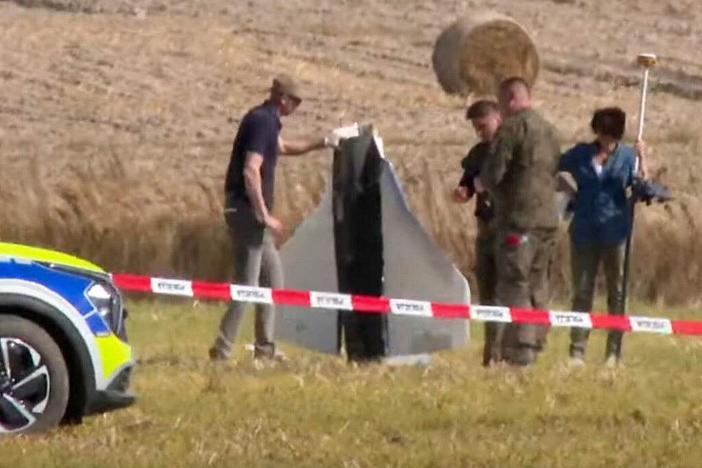 Sicherheitsleute heben die Überreste einer russischen Drohne auf einem Feld in Polen auf.