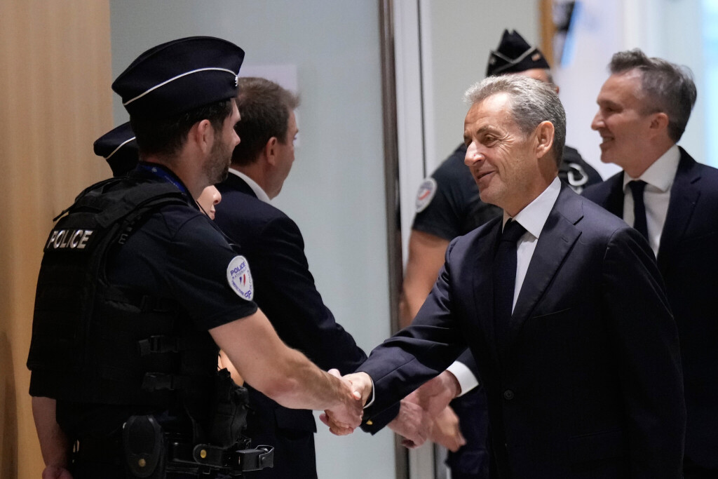 Former French President Nicolas Sarkozy shakes hands with a police officer before his verdict for alleged illegal financing of his 2007 presidential campaign by the government of then-Libyan leader Moammar Gadhafi, Thursday, Sept. 25, 2025 in Paris. (AP Photo/Michel Euler)