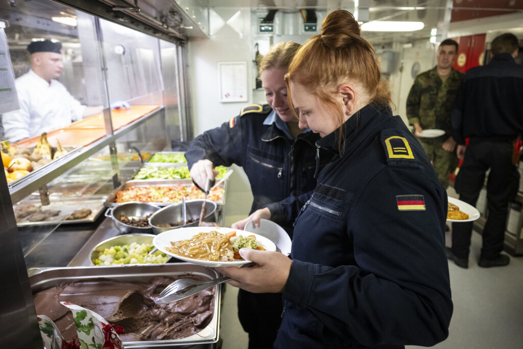Soldatinnen der Marine stehen bei der Essensausgabe an Bord des Tenders "Donau".