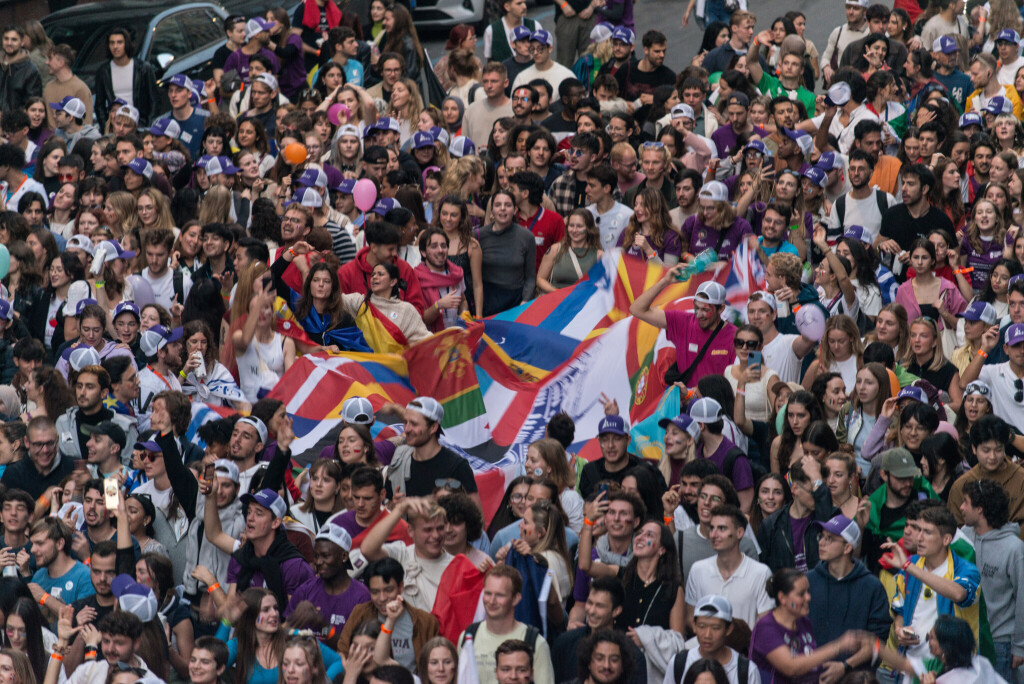 Bei einem Treffen des Erasmus-Netzwerks trägt eine Menschenmenge eine Banner, das aus zusammengenähten Nationalflaggen besteht.