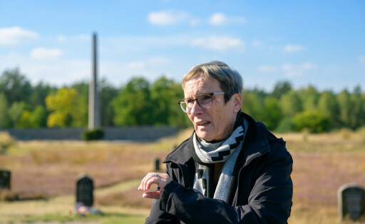 Elke Gryglewski steht sprechend auf einem Friedhof.