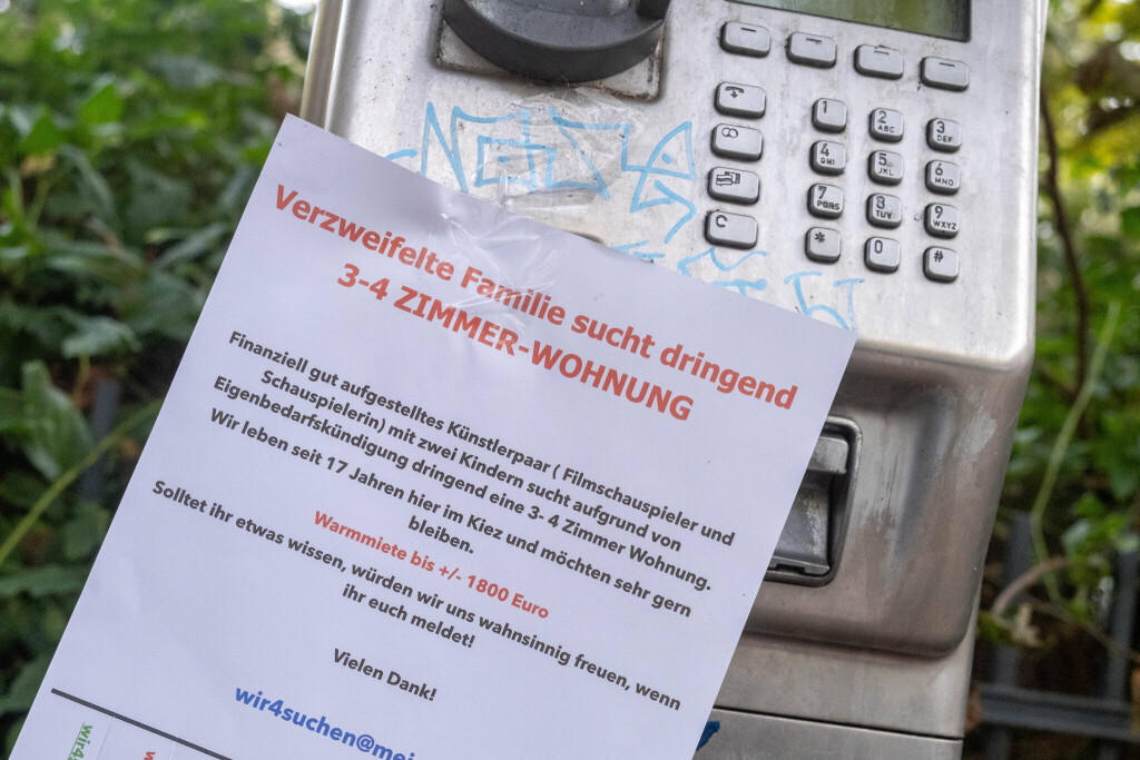 Verzweifeltes Wohnungsgesuch hängt an einem funktionuntüchtigen öffentlichen Telefon