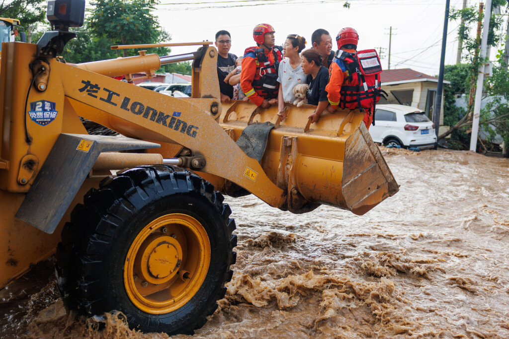 Rescuers transfer disaster-affected evacuees with front loaders on July 28, 2025 in Beijing, China.