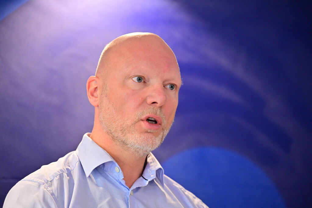 Jörgen Warborn vor blauem Hintergrund.