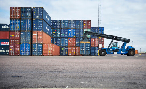 Gestapelte Schiffscontainer und ein fahrbarer Container-Kran