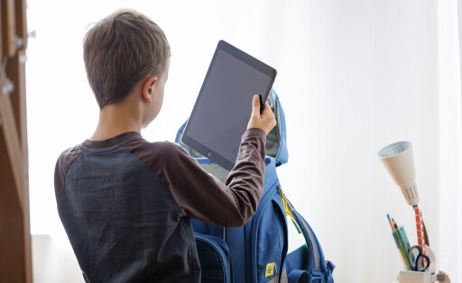 Ein Schüler packt ein Tablet in seinen Schulranzen.
