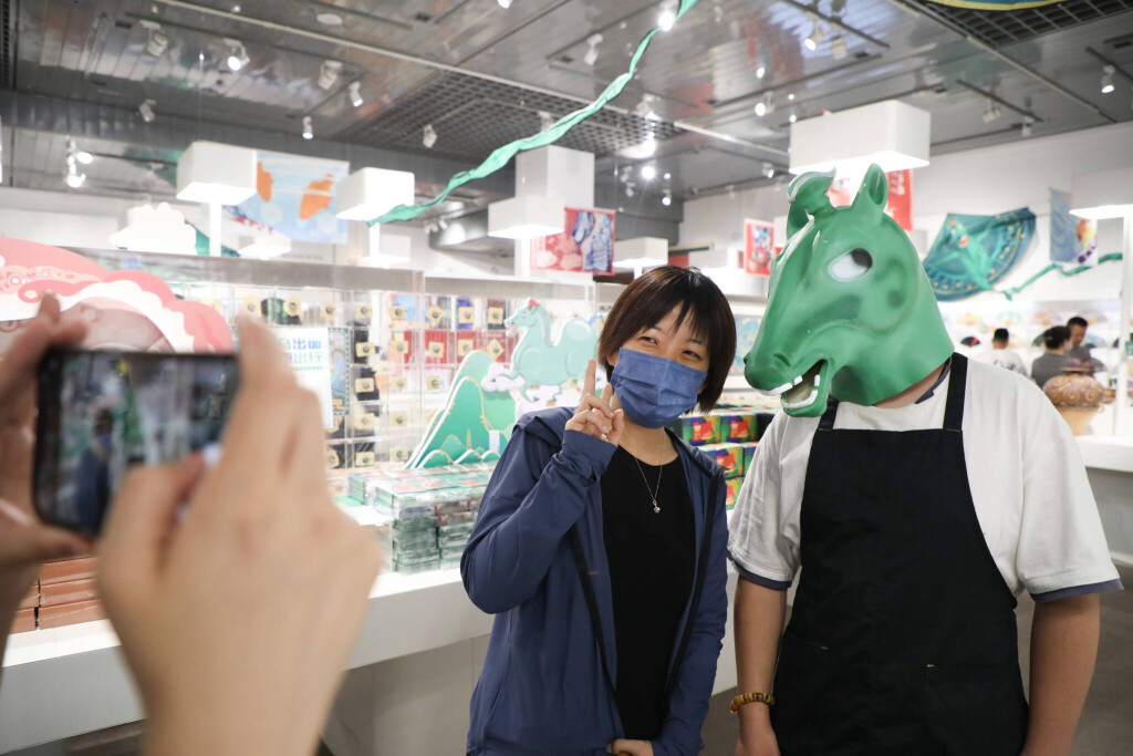 (220628) -- LANZHOU, June 28, 2022 -- A tourist (L) poses for photos with a staff member wearing headgear featuring an a