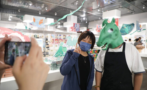 (220628) -- LANZHOU, June 28, 2022 -- A tourist (L) poses for photos with a staff member wearing headgear featuring an a