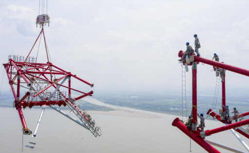 220816 -- TONGLING, Aug. 16, 2022 -- Aerial photo taken on Aug. 16, 2022 shows utility technicians working at the construction site of the north power transmission tower of the Baihetan-Zhejiang 800-kilovolt ultra-high-voltage UHV direct current power transmission project over the Yangtze River in Tongling, east China s Anhui Province. The construction work on the north power transmission tower of Baihetan-Zhejiang 800-kilovolt UHV direct current power transmission project has been completed on Tuesday, marking the completion of all power transmission towers across the Yangtze River of the Anhui section of the project. Covering a total length of 2,140.2 kilometers, the project is an important part of the China s west-to-east power PUBLICATIONxNOTxINxCHN