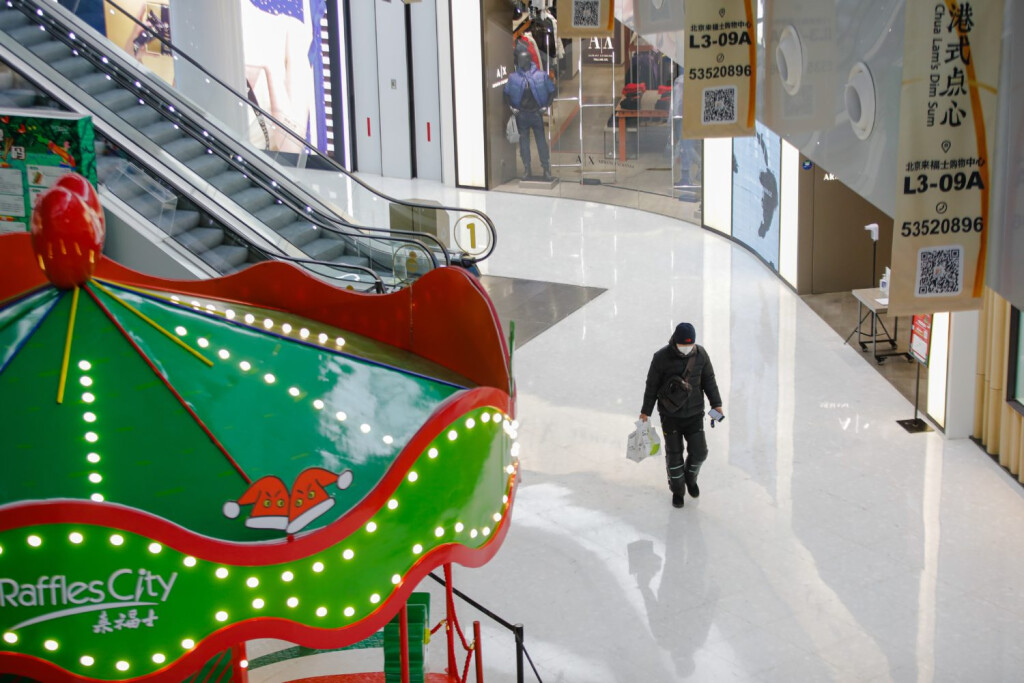epa10341007 A delivery man wearing a face mask walks at Raffles city shopping mall in Beijing, China, 01 December 2022. Many shopping malls in Beijing, including Raffles City and Shunyi Longhua Outlets Shopping Plaza, announced the reopening of the malls from 01 December 2022, with a negative PCR test result taken within 48 hours for customers to enter. EPA-EFE/WU HAO