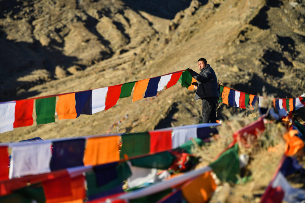 230124 -- XIGAZE, Jan. 24, 2023 -- A man hangs prayer flags on a mountain in Xigaze, southwest China s Tibet Autonomous Region, Jan. 24, 2023. Following the tradition, people here went early in the morning to hang new prayer flags on top of mountains and their house roofs to celebrate New Year under the Tibetan calendar. InTibet CHINA-TIBET-XIGAZE-NEW YEAR-PRAYER FLAG CN JigmexDorje PUBLICATIONxNOTxINxCHN
