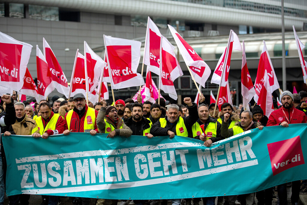 epa10472707 Workers hold union flags and a banner reading: 'Together goes more' at a demonstration outside of the international airport in Frankfurt am Main, Germany, 17 February 2023. Following the strike announcement by the trade union ver.di, the operators of the airports in Frankfurt, Munich and Hamburg have announced that they will cease regular operations on Friday 17 February. All take-offs and landings of passenger flights and commercial connections are likely to be cancelled. According to the airport association ADV, the warning strike will lead to a good 2340 flight cancellations and could thus affect around 295.000 passengers. EPA-EFE/HOSAM KATAN