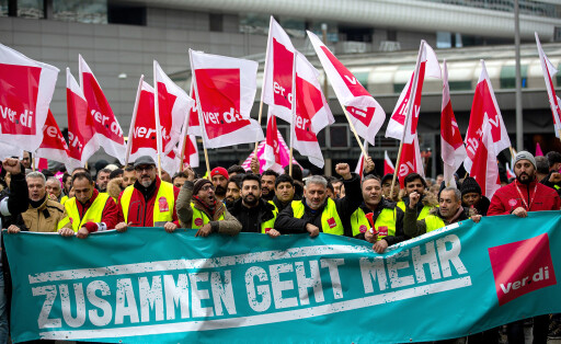 epa10472707 Workers hold union flags and a banner reading: 'Together goes more' at a demonstration outside of the international airport in Frankfurt am Main, Germany, 17 February 2023.  Following the strike announcement by the trade union ver.di, the operators of the airports in Frankfurt, Munich and Hamburg have announced that they will cease regular operations on Friday 17 February. All take-offs and landings of passenger flights and commercial connections are likely to be cancelled. According to the airport association ADV, the warning strike will lead to a good 2340 flight cancellations and could thus affect around 295.000 passengers.  EPA-EFE/HOSAM KATAN