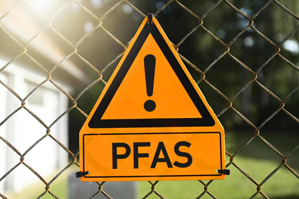 FOTOMONTAGE, Gefahrenschild mit Ausrufezeichen und Aufschrift PFAS *** PHOTOMONTAGE, danger sign with exclamation mark and inscription PFAS