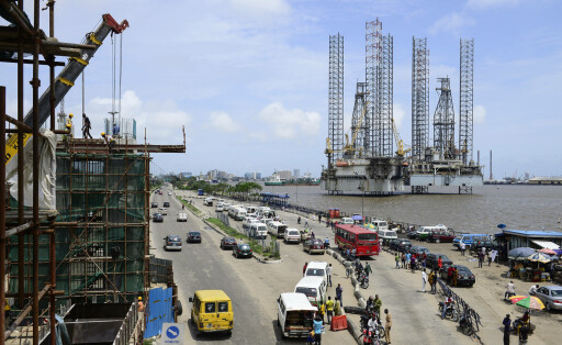 Nigeria Lagos, chinese CCECC Metro train construction and oil platform in Lagos port NIGERIA, City Lagos, two oil platform laying in Lagos port, Oritsetimeyin and Onome, and left flyover construction for new metro train by chinese company CHINA CIVIL CCECC, road traffic with VW minibus Lagos Lagos Nigeria