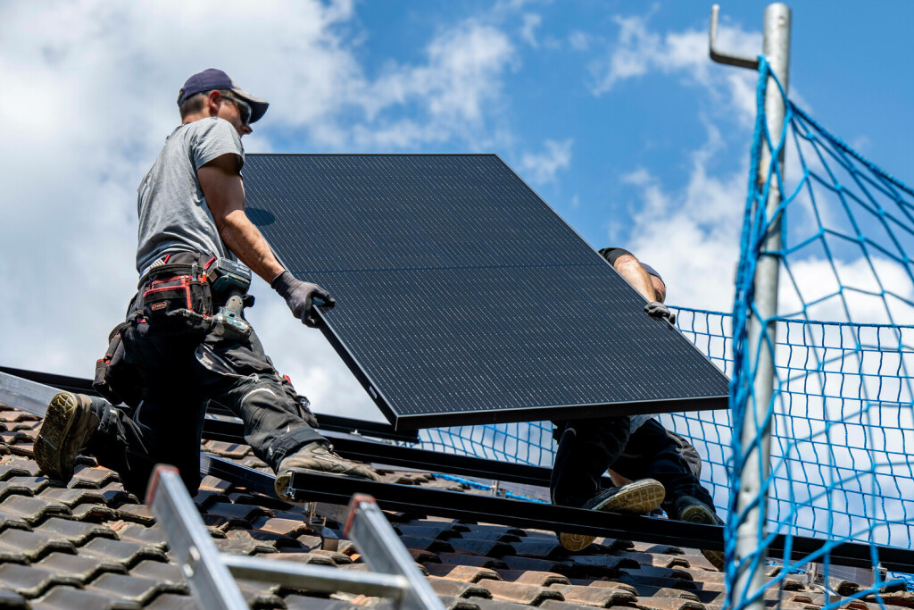 Solarenergie Wirtschaft, Bauen, Solarenergie: Arbeiter installieren eine Photovoltaikanlage auf dem Dach eines Hauses. Rietberg Nordrhein-Westfalen Deutschland *** Solar Energy Economy, Building, Solar Energy Workers install a photovoltaic system on the roof of a house Rietberg North Rhine Westphalia Germany Copyright: xDavidxInderliedx